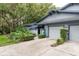 Exterior shot highlighting the well-manicured landscaping, driveway and attached garage at 60 Birdsong Ct, Oldsmar, FL 34677