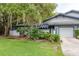 Charming home featuring an attached garage, beautiful landscaping, and a well-maintained lawn at 60 Birdsong Ct, Oldsmar, FL 34677
