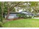 View of the home's exterior showing lush greenery, mature trees and a well-maintained lawn at 60 Birdsong Ct, Oldsmar, FL 34677