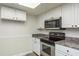 Kitchen area offering stainless steel appliances, granite countertops, and white cabinetry at 60 Birdsong Ct, Oldsmar, FL 34677