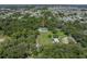 Aerial view of the property showcases its location nestled among mature trees at 7427 20Th St, Zephyrhills, FL 33540