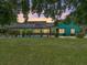 Backyard view of a screened-in pool and exterior of the home in the early evening at 7427 20Th St, Zephyrhills, FL 33540