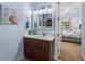 Bathroom vanity and decor with bright mirror and adjacent bedroom door at 7427 20Th St, Zephyrhills, FL 33540