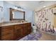 Charming bathroom featuring granite counters, decorative mirror, and shower with butterfly curtain at 7427 20Th St, Zephyrhills, FL 33540