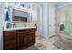 Bathroom featuring a wood vanity, framed mirror, and access to an ensuite bedroom and backyard at 7427 20Th St, Zephyrhills, FL 33540