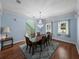 Bright dining room features hardwood floors, elegant chandelier and staircase access at 7427 20Th St, Zephyrhills, FL 33540