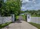 Private driveway gate leads to this estate home with lush landscaping and mature trees at 7427 20Th St, Zephyrhills, FL 33540