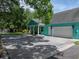 This stunning home features a teal exterior, a large garage, and beautiful curb appeal at 7427 20Th St, Zephyrhills, FL 33540