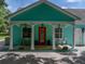 Inviting home showcasing a cozy front porch with seating and a striking red door at 7427 20Th St, Zephyrhills, FL 33540