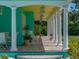Expansive covered porch with detailed columns, seating, and a brick floor at 7427 20Th St, Zephyrhills, FL 33540
