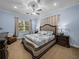 Spacious main bedroom with a large window, decorative bedding, and a ceiling fan at 7427 20Th St, Zephyrhills, FL 33540