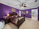 Spacious main bedroom offers plush carpeting, ceiling fan and ensuite access at 7427 20Th St, Zephyrhills, FL 33540