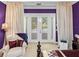 Cozy bedroom features a plush chair with French doors and ample natural light at 7427 20Th St, Zephyrhills, FL 33540