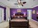 This is a large main bedroom with purple walls, ceiling fan and ensuite bath at 7427 20Th St, Zephyrhills, FL 33540