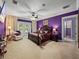 Large main bedroom with purple walls, French doors to pool, and ceiling fan at 7427 20Th St, Zephyrhills, FL 33540