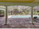 Covered pool area showcasing the refreshing pool and outdoor lounging space with elegant columns at 7427 20Th St, Zephyrhills, FL 33540