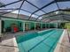 Back exterior shot of the full pool showcasing the large patio with seating and screened-in pool enclosure at 7427 20Th St, Zephyrhills, FL 33540