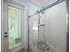 Shower featuring glass doors, white tile, and a door to the backyard at 7427 20Th St, Zephyrhills, FL 33540