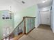 Upper landing with decorative railing offers views of the home's entrance and bright interior at 7427 20Th St, Zephyrhills, FL 33540
