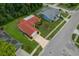 Aerial view of a well-maintained property with a red roof, lush green lawn, and mature landscaping at 8671 Cypress Lakes Blvd, New Port Richey, FL 34653