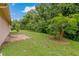 Expansive backyard featuring lush greenery and a decorative tree, creating a serene outdoor space at 8671 Cypress Lakes Blvd, New Port Richey, FL 34653