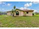 A backyard featuring a well-maintained lawn and a view of the home's exterior at 8671 Cypress Lakes Blvd, New Port Richey, FL 34653