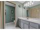 Bathroom with a marble countertop, white tile flooring, and updated fixtures at 8671 Cypress Lakes Blvd, New Port Richey, FL 34653