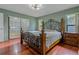 Bedroom features a decorative metal bed frame, wood floors, and natural light at 8671 Cypress Lakes Blvd, New Port Richey, FL 34653
