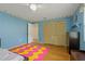 Bright bedroom featuring blue walls, wood-look floors, and a double closet at 8671 Cypress Lakes Blvd, New Port Richey, FL 34653