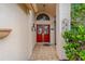 Inviting covered front porch with a decorative red double door and tiled flooring at 8671 Cypress Lakes Blvd, New Port Richey, FL 34653