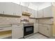 Cozy kitchen with stainless steel oven, white cabinetry and tiled backsplash at 8671 Cypress Lakes Blvd, New Port Richey, FL 34653