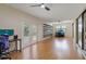 Spacious living room featuring wood floors, a ceiling fan, shelves, and sliding doors to the outside at 8671 Cypress Lakes Blvd, New Port Richey, FL 34653