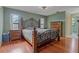 Spacious bedroom featuring wood floors, large windows, and decorative wrought iron bed frame at 8671 Cypress Lakes Blvd, New Port Richey, FL 34653