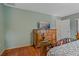 Bedroom featuring hardwood floors, a TV, and neutral colored walls, offering a cozy retreat within the home at 8671 Cypress Lakes Blvd, New Port Richey, FL 34653