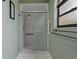 Bright bathroom featuring a tiled shower with glass sliding doors, and accessibility bars at 8671 Cypress Lakes Blvd, New Port Richey, FL 34653