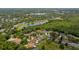 Wide aerial view of homes surrounded by lush greenery and serene lake at 9206 Brindlewood Dr, Odessa, FL 33556