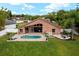 Aerial view of a backyard with a pool, fire pit, and patio at 9206 Brindlewood Dr, Odessa, FL 33556