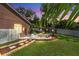 Backyard features a stone fire pit and landscaped seating area at 9206 Brindlewood Dr, Odessa, FL 33556