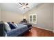 This bedroom features wood floors, a ceiling fan, and a window for natural light at 9206 Brindlewood Dr, Odessa, FL 33556
