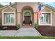 Inviting home featuring a charming arched entryway, beautiful front door, and lovely landscaping at 9206 Brindlewood Dr, Odessa, FL 33556