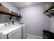 A laundry room with side by side washing machine and dryer, overhead shelving at 9206 Brindlewood Dr, Odessa, FL 33556