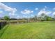 Expansive backyard with green grass, fence, and a serene pond view at 9672 Ivory Dr, Ruskin, FL 33573