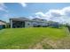 Expansive backyard with green lawn, black metal fence and screened in patio at 9672 Ivory Dr, Ruskin, FL 33573