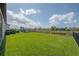 Large backyard with green lawn, black metal fence and playground at 9672 Ivory Dr, Ruskin, FL 33573