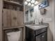 Charming bathroom featuring granite counters, grey cabinets, and a decorative storage cabinet above the toilet at 9672 Ivory Dr, Ruskin, FL 33573