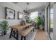 Bright dining room features a wooden table and bench set, modern lighting, and sliding doors for outdoor access at 9672 Ivory Dr, Ruskin, FL 33573