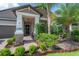 Inviting front porch with brick columns and walkway, complemented by verdant landscaping and palm trees at 9672 Ivory Dr, Ruskin, FL 33573