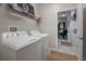 A bright laundry room features modern washer and dryer units, tiled flooring, and access to other rooms at 9672 Ivory Dr, Ruskin, FL 33573