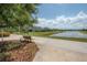 A serene pond view with a walking path, bench, and manicured landscaping at 9672 Ivory Dr, Ruskin, FL 33573