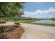 A serene pond view with a walking path, bench, and manicured landscaping at 9672 Ivory Dr, Ruskin, FL 33573